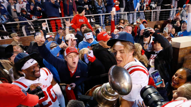 Nov 23, 2023; Starkville, Mississippi, USA; Mississippi Rebels quarterback Jaxson Dart (2) shares the Egg Bowl trophy with fans after defeating the Mississippi State Bulldogs at Davis Wade Stadium at Scott Field. Mandatory Credit: Petre Thomas-USA TODAY Sports